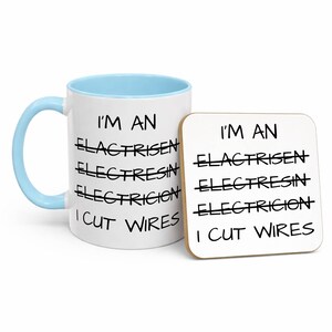 May include: A white ceramic mug with a light blue handle and interior, paired with a square coaster. Both items feature the black text: I'M AN ELACTRISEN, ELECTRESIN, ELECTRICION, I CUT WIRES, with the first three words crossed out with lines.