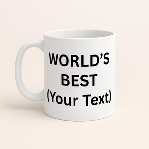 Puede incluir: Una taza de cer&aacute;mica blanca con un asa curvada. La taza presenta el texto "WORLD'S BEST (Your Text)" en negro, con letras en negrita. La taza est&aacute; dise&ntilde;ada para bebidas y es adecuada para uso dom&eacute;stico o de oficina.