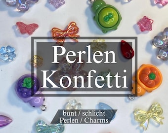 Puede incluir: Una colección de abalorios y cuentas de colores en varias formas, incluyendo flores, mariposas, lazos y tortugas. La imagen presenta el texto "Perlen Konfetti" y "bunt / schlicht Perlen / Charms". Las cuentas son en tonos rosa, morado, verde y naranja.
