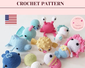 May include: A collection of crocheted sea creatures, including a dolphin, a crab, a seahorse, a pufferfish, a turtle, a starfish, and a mermaid. The crocheted animals are all in various shades of blue, pink, yellow, and white.