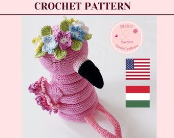 May include: Pink crocheted flamingo toy with a flower crown. The toy has long legs and a black beak. The image includes the text "download pdf-pattern" and the words "Crochet Pattern" and "Smoozy Crochet patterns".