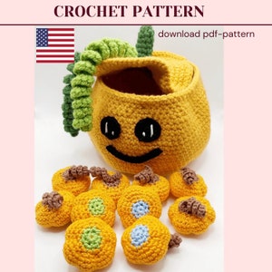 May include: A crocheted pumpkin basket with a smiling face and a green stem. The basket is filled with smaller crocheted pumpkins in various colours, including orange, green, and blue.