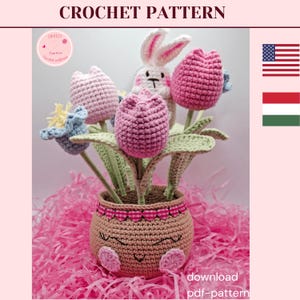 Puede incluir: Un arreglo floral de ganchillo con tulipanes rosas, flores azules y un conejito blanco en una maceta marrón. La maceta tiene una cara sonriente y detalles en rosa. El texto "CROCHET PATTERN" está en la parte superior y "download pdf-pattern" en la inferior.