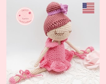 May include: Crochet pattern for a ballerina doll with a pink dress, pink hair, and purple ribbon. The doll is sitting in a split position with her legs extended. The pattern is available for download as a PDF.