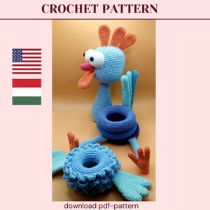 May include: Crochet pattern for a blue and orange rooster toy. The rooster has a large head with big eyes and a long beak. The rooster is standing on a stack of blue rings. The pattern is available for download as a PDF.