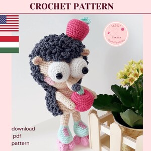 May include: A handmade crochet doll with large white eyes, dark gray hair, and a pink apple on its head. The doll is wearing roller skates and holding a pink apple. The words "CROCHET PATTERN" and "download pdf pattern" are visible.