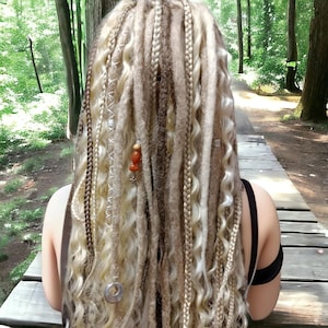 May include: A set of long, blonde and brown synthetic dreadlocks with beads and charms. The dreadlocks are styled in a variety of textures, including straight, wavy, and curly.
