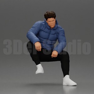 May include: A miniature figurine of a person with dark hair, wearing a blue puffer jacket, black pants, and white sneakers. The figure is in a seated, crouching position. The text 3DerStudio is visible in the background behind the figurine.