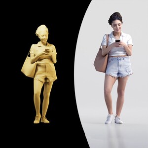May include: A woman wearing a white shirt and denim shorts is looking down at her phone. She is carrying a brown handbag over her shoulder.