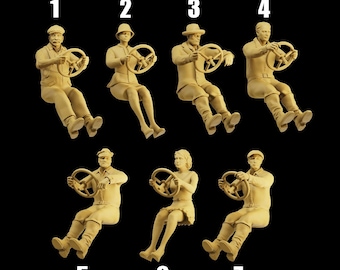 May include: Seven figurines of people driving, each with a steering wheel. The figurines are in various poses and are made of a light brown material.
