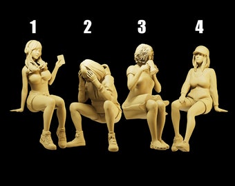 May include: Four beige-colored resin figurines of seated figures. Each figure is in a different pose, with one holding a phone, another with their head in their hands, one drinking from a mug, and the last wearing a hat.