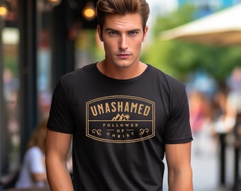 Puede incluir: Una camiseta negra con un gráfico dorado que dice "UNASHAMED - FOLLOWER OF CHRIST" con un diseño de montaña y sol.