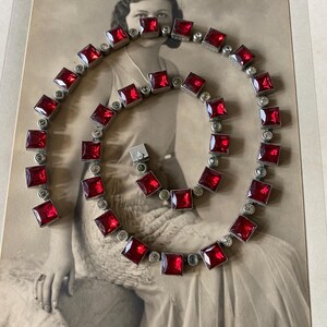 May include: A vintage red and silver necklace with square-shaped stones. The necklace is made of metal and has a clasp closure.