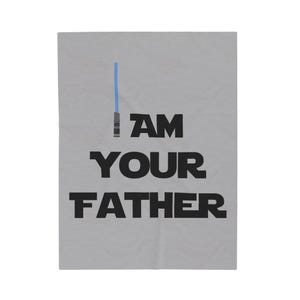Puede incluir: Textil rectangular gris claro con el texto "I AM YOUR FATHER" en letras negras en negrita. Un sable de luz azul está representado encima del texto. El diseño es simple y gráfico.
