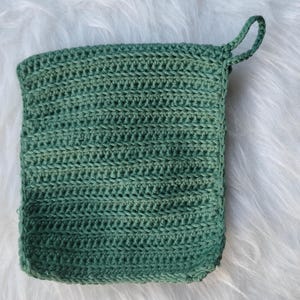 Peut inclure: Un porte-pot en crochet vert avec une anse.