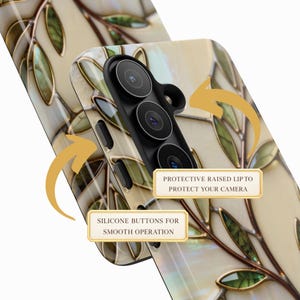 May include: A phone case featuring a cream-colored background with a pattern of brown branches and green leaves. The case includes a black camera housing with a protective raised lip and silicone buttons. Text labels read: PROTECTIVE RAISED LIP TO PROTECT YOUR CAMERA and SILICONE BUTTONS FOR SMOOTH OPERATION.