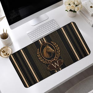 Peut inclure: Tapis de bureau noir et or avec un emblème de tête de cheval, une couronne de laurier et la lettre "W". Le tapis présente des rayures verticales dorées sur un fond sombre. Mesure environ 70 cm de long.