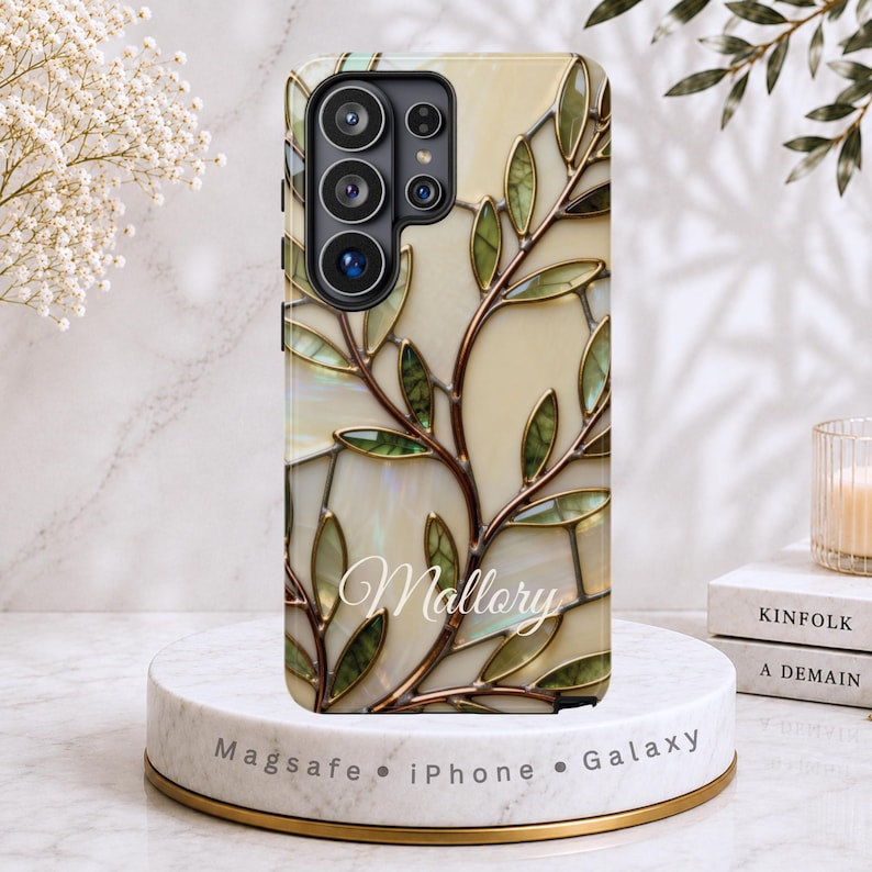Stained glass botanical phone case featuring an elegant branch and leaf design in soft ivory and muted green tones with warm metallic outlines. Nature-inspired art phone case shown on a protective case for iPhone, Samsung Galaxy. A refined, neutral phone case designed for women who prefer calm, minimalist, and art-forward accessories. Samsung Galaxy S26