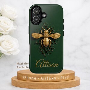 May include: A dark green phone case featuring a gold-colored bee design on a honeycomb pattern. The name "Allison" is scripted in gold. The case is displayed on a wooden stand with the text "iPhone • Galaxy • Pixel".