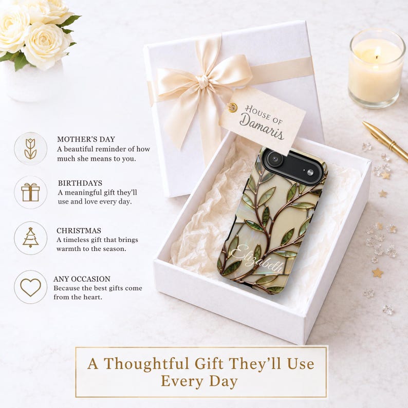 May include: A phone case featuring a stained glass-style pattern of green leaves and brown branches on a cream background, with the name Elizabeth printed in white script. The case is inside a white gift box with a ribbon and a House of Damaris tag.