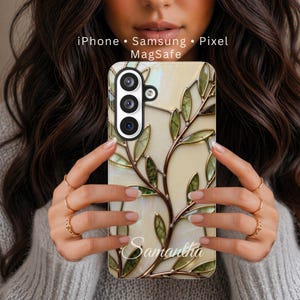 May include: A phone case with a stained-glass design featuring green leaves and brown stems. The case is personalized with the name "Samantha" in a script font. The case is compatible with iPhone, Samsung, and Pixel phones and has MagSafe compatibility.