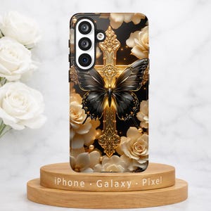 May include: A phone case featuring a black butterfly with gold accents, set against a gold cross and cream-colored roses. The case is on a wooden stand, with the words "iPhone Galaxy Pixel" at the base.