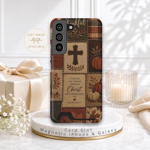 May include: A rectangular phone case featuring a patchwork design with autumn-themed illustrations including pumpkins, leaves, and a cross. The text reads, I CAN DO ALL THINGS THROUGH CHRIST WHO STRENGTHENS ME PHILIPPIANS 4:13, with a small heart icon.