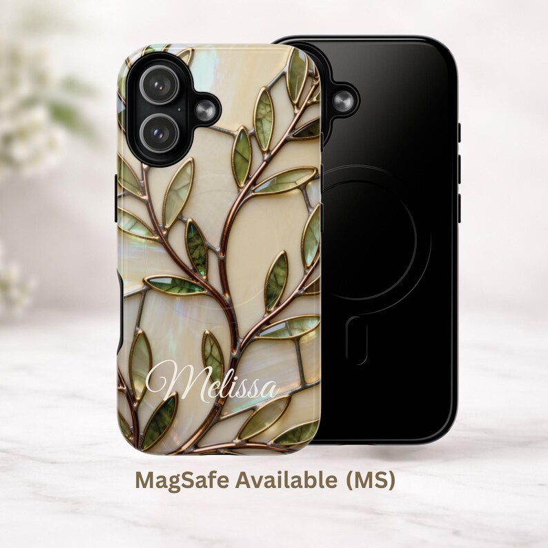 May include: A phone case featuring a stained glass-style pattern of green leaves and brown branches on a cream background. The name Melissa is printed in white script. A second black phone case with a circular MagSafe magnetic ring is visible.