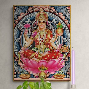 Puede incluir: Una pintura colorida de una diosa hindú sentada en una flor de loto. La diosa lleva un sari rojo y dorado y una corona de flores. Sostiene una olla en una mano y una flor en la otra. La pintura está rodeada por un mandala azul y dorado.