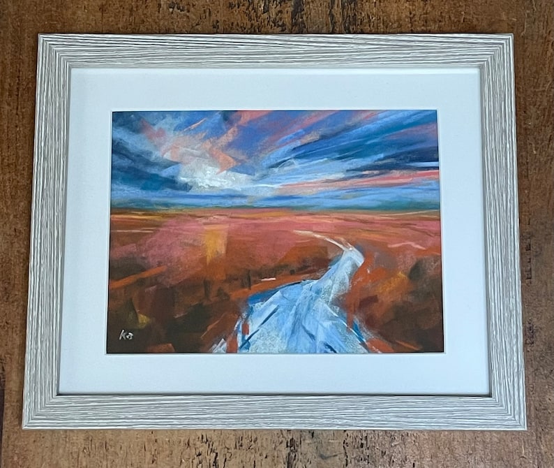 May include: A framed pastel painting of a landscape with a blue river flowing through a field of orange and pink hues under a dramatic sky with clouds in shades of blue, pink, and purple.