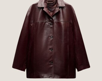 Puede incluir: Chaqueta de cuero burdeos con cuello y cierre de botones. La chaqueta tiene un diseño clásico con un corte entallado, mangas largas y un acabado liso y pulido. La chaqueta es una prenda de abrigo versátil.