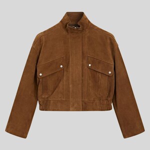 May include: A brown suede jacket with a stand-up collar and two front pockets. The jacket has a fitted waist and long sleeves. The jacket is a medium brown color and has silver button closures on the pockets.