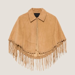 May include: A tan suede cape with a collar and a zipper closure. The cape features decorative fringe along the bottom edge. The garment is a neutral color and is suitable for various outfits.