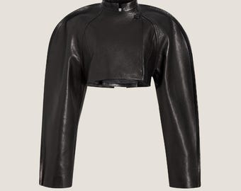 Puede incluir: Una chaqueta corta de cuero negro con mangas largas y cuello alto.