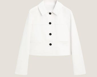 May include: A white cropped denim jacket with a button-up front and two flap pockets.