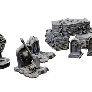 Op de afbeelding: Een set miniatuur kerkhofdecoraties, inclusief een kruis, grafstenen en een kist met kettingen. De stukken zijn gemaakt van grijs plastic en zijn ontworpen voor tabletop gaming of miniatuurdioramas.