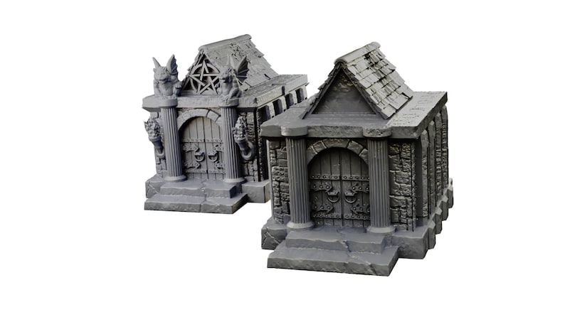 Op de afbeelding: Twee miniatuur stenen mausolea met gewelfde deuren en gedetailleerd steenwerk. Een mausoleum heeft waterspuwers en een pentagram op het dak.