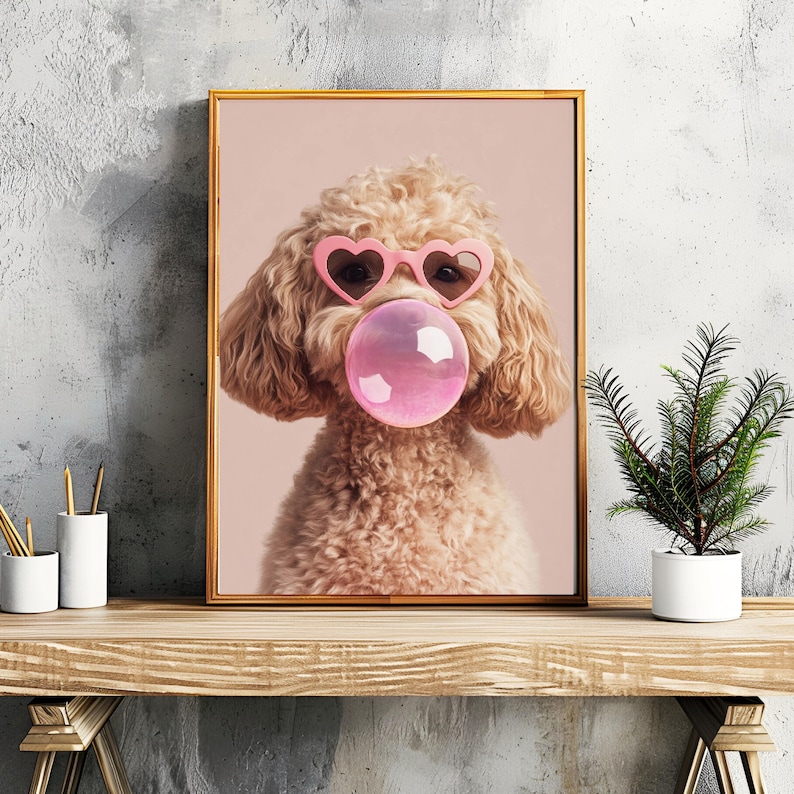 May include: A light brown poodle wearing pink heart-shaped sunglasses and blowing a pink bubble. The dog is looking directly at the camera.