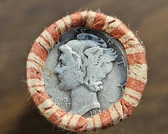 May include: A silver 1945 Mercury dime coin in a red and white paper coin wrapper.