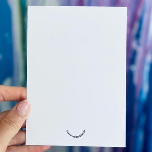 May include: Blank white card with a small, black, circular logo that reads "Happy Tiger Design".