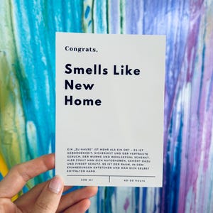 eine weiße Karte zum Einzug. eine minimalistische Karte mit„Congrats,“ und darunter sehr präsent gedruckt „Smells Like new home“.
darauf folgt:EIN „ZU HAUSE" IST MEHR ALS EIN ORT - ES IST
GEBORGENHEIT, SICHERHEIT UND DER VERTRAUTE GERUCH.