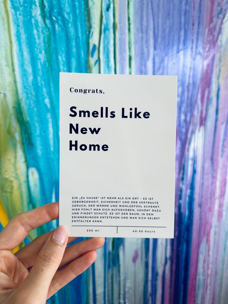 eine weiße Karte zum Einzug. eine minimalistische Karte mit„Congrats,“ und darunter sehr präsent gedruckt „Smells Like new home“.
darauf folgt:EIN „ZU HAUSE" IST MEHR ALS EIN ORT - ES IST
GEBORGENHEIT, SICHERHEIT UND DER VERTRAUTE GERUCH.