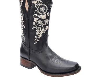May include: Black leather cowboy boots with a floral embroidery design in white thread. The boots have a pointed toe and a low heel.
