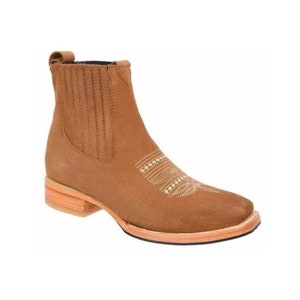 May include: Brown suede ankle boots with a decorative stitch design on the side. The boots have a low heel and a pull-on style.