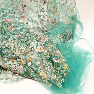 a close-up view of a fabric with a floral pattern, featuring a mix of green and white colors.