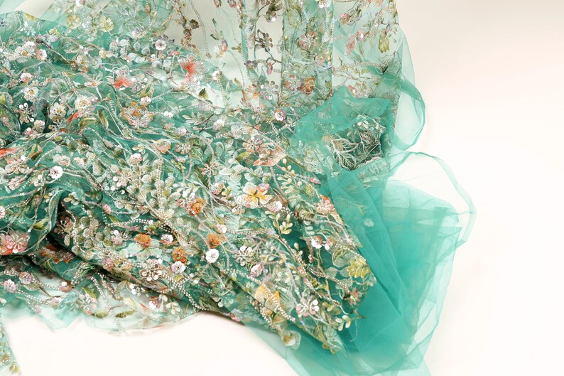 a close-up view of a fabric with a floral pattern, featuring a mix of green and white colors.