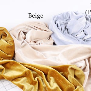 three different colored fabrics: gold, beige, and silver, arranged on a white background.
