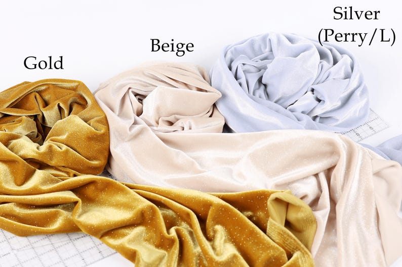 three different colored fabrics: gold, beige, and silver, arranged on a white background.