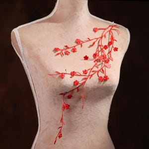 Puede incluir: Aplique de bordado floral rojo con ramas delicadas y pequeñas flores. Este aplique es perfecto para agregar un toque de elegancia a la ropa, los accesorios o los proyectos de decoración del hogar.