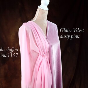 A mannequin wearing a pink chiffon dress with a metallic sheen, set against a dark background.